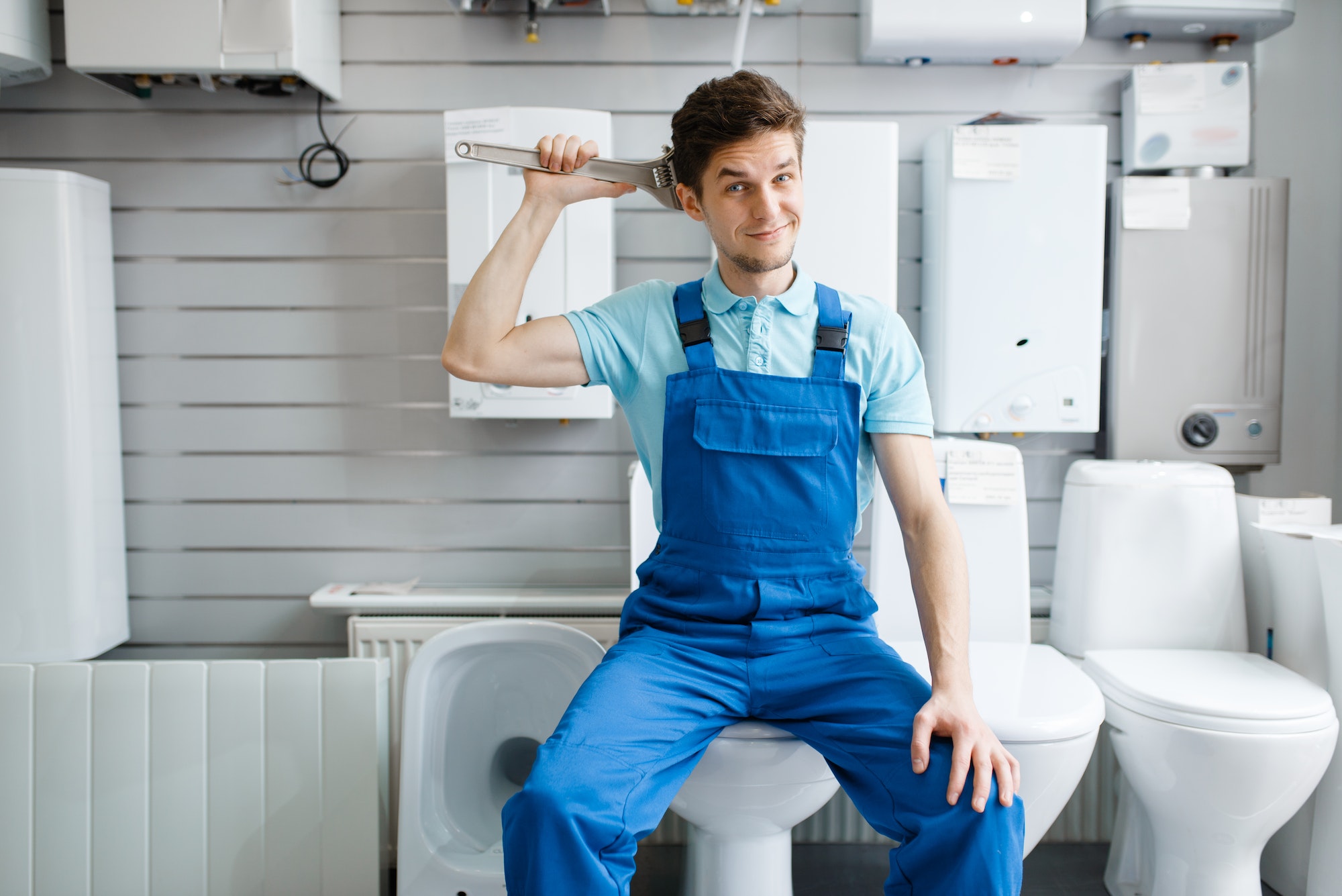 Plumber sitting on toilet in plumbering store